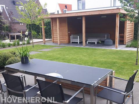 Tuinaanleg met terras, gazon en houten overkapping