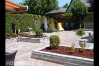 Tuinaanleg met bestrating en plantenbakken van gestapelde stenen