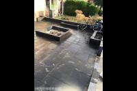 Voortuin met natuursteen tegels en plantenbakken