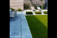 Achtertuin met tegels, grasmat en kiezels