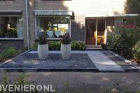 Onderhoudsvriendelijke voortuin met bestrating, split en bloempotten