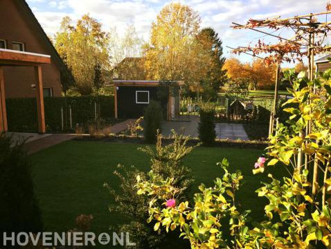 Tuin met hoogteverschil en overkapping en schuurtje van Douglas hout