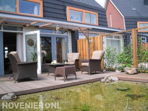 Houten vlonder met pergola bij heldere vijver