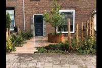 Voortuin met cortenstaal plantenbak en houten palen ter decoratie