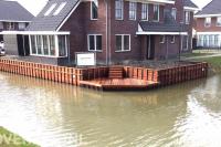 Houten beschoeiing en vlonder langs het water