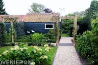 Tuin met pergola, grindpad en veel groen