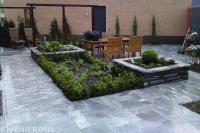 Strakke tuin met pergola en bestrating van natuursteen