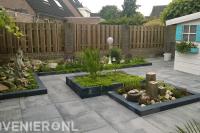 Tuinaanleg met sierbestrating en borders met nieuwe beplanting