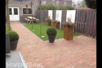 Moderne tuin met kunstgras, cortenstaal plantenbakken en leibomen 2