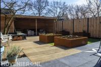 Strakke achtertuin met plantenbakken