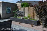 Verhoogde border van stapelblokken met watermuur