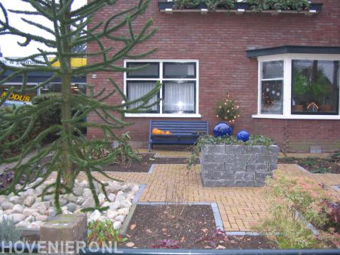 Apenboom en plantenbak van stapelblokken in voortuin 2