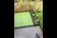 Bovenaanzicht tuin met kunstgras en natuurstenen tegels