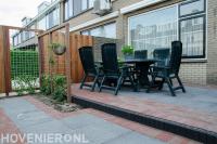 Tuin met houten schutting en bestrating van klinkers en betontegels 2