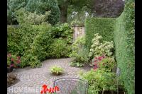 Groene tuin met kleurrijke beplanting en bestrating van koppelstenen 2