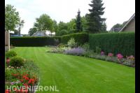 Strak groen gazon en borders met kleurrijke planten