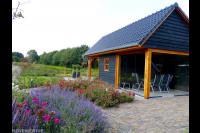 Veranda met glazen schuifwanden bij houten schuur