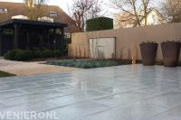 Strakke tuin met overkapping, vijver en keramische tegels