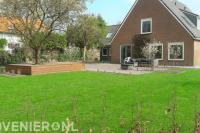 Ruime tuin met groot gazon en terras