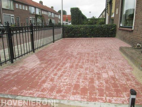 Voortuin met bestrating van rode betonklinkers en sierhek