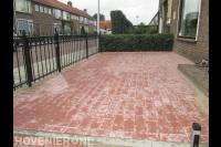 Voortuin met bestrating van rode betonklinkers en sierhek