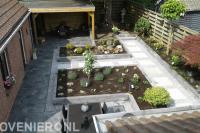 Onderhoudsarme achtertuin met bestrating en verhoogde plantenbakken