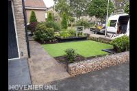 Voortuin aanleggen met kunstgras, schanskorf en nieuwe beplanting