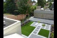 Moderne tuin met bestrating, kunstgras en houten pergola