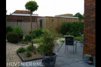 Tuin met terras van betontegels en grindpaden