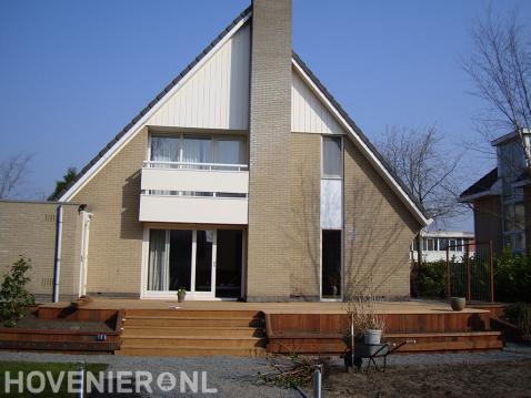 Grote houten vlonder met trap bij woning