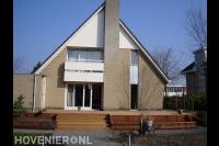 Grote houten vlonder met trap bij woning