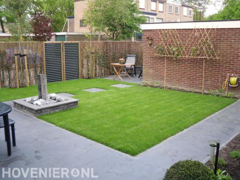 Hedera schutting met maten van wilgentenen en leibomen in achtertuin