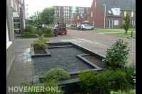 Onderhoudsarme voortuin met plantenbakken en split