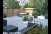 Strakke tuin met bestrating van grote antraciet tuintegels