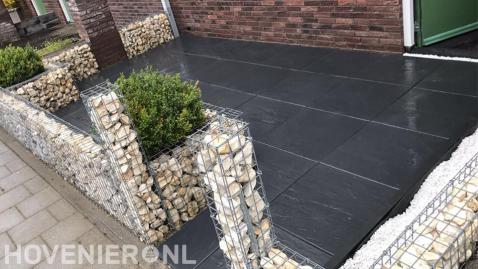 Voortuin met sierbestrating en schanskorven