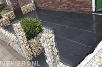 Voortuin met sierbestrating en schanskorven
