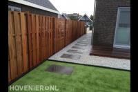 Vlonder, houten schutting en kunstgras en grind met stapstenen.