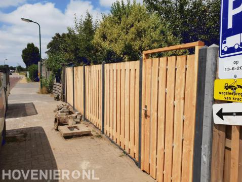 Houten schutting met betonpalen en tuinpoort