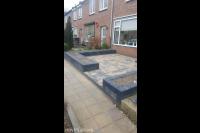 Onderhoudsarme voortuin met betontegels en plantenbakken