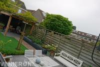 Tuin met houten overkapping en dakplatanen