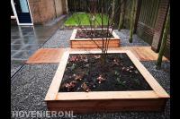 Tuin met houten vlonder en plantenbakken van hout