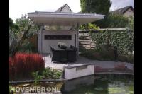 Terras met luxe overkapping bij vijver met watermuur