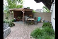 Achtertuin met sierbestrating en overkapping