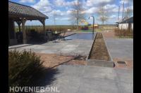 Moderne tuin met zwembad, overkapping en grote tuintegels