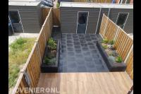 Onderhoudsarme tuin met sierbestrating, plantenbakken en schutting