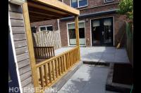 Achtertuin met bestrating en houten veranda