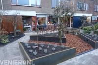 Voortuin met verhoogde borders en bodembedekking van boomschors