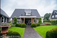 Tuinaanleg met bestrating, gazon en houten overkapping