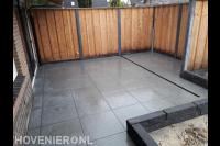 Achtertuin met sierbestrating, schutting en plantenbak