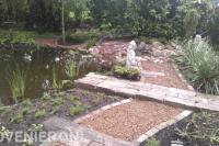 Grindpad en rotsblokken bij grote vijver